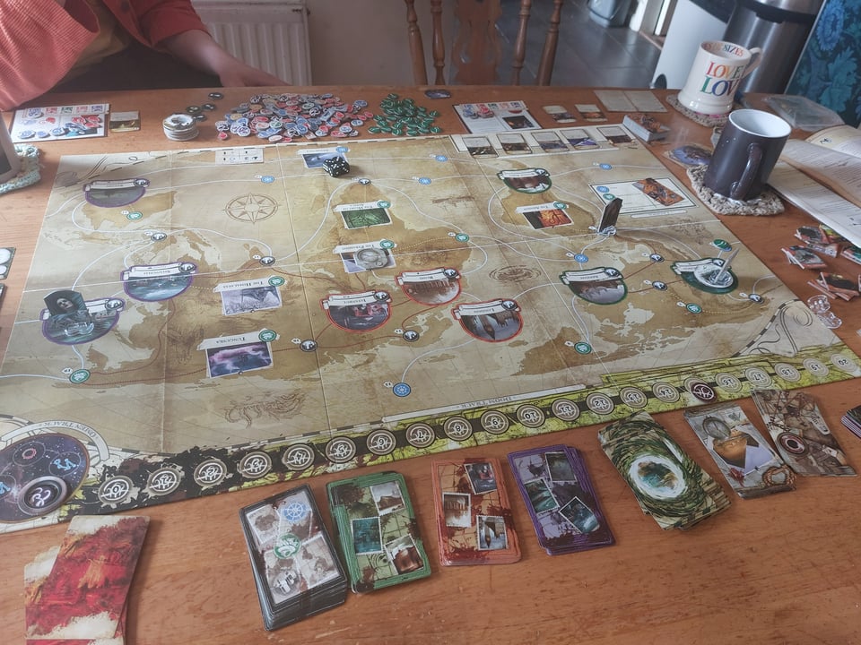 The game board, and multiple associated decks of cards. Also some mugs of tea.