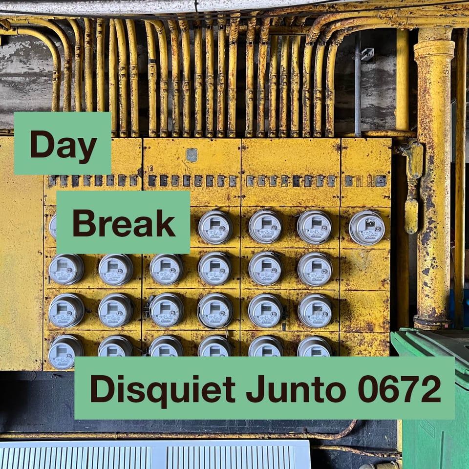 The image shows a bright yellow contraption covered with electric meters for an apartment building. It's dirty. On top of it are the name and number of the project.