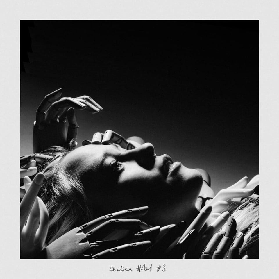 a woman laying down with wooden life drawing hand touch her face