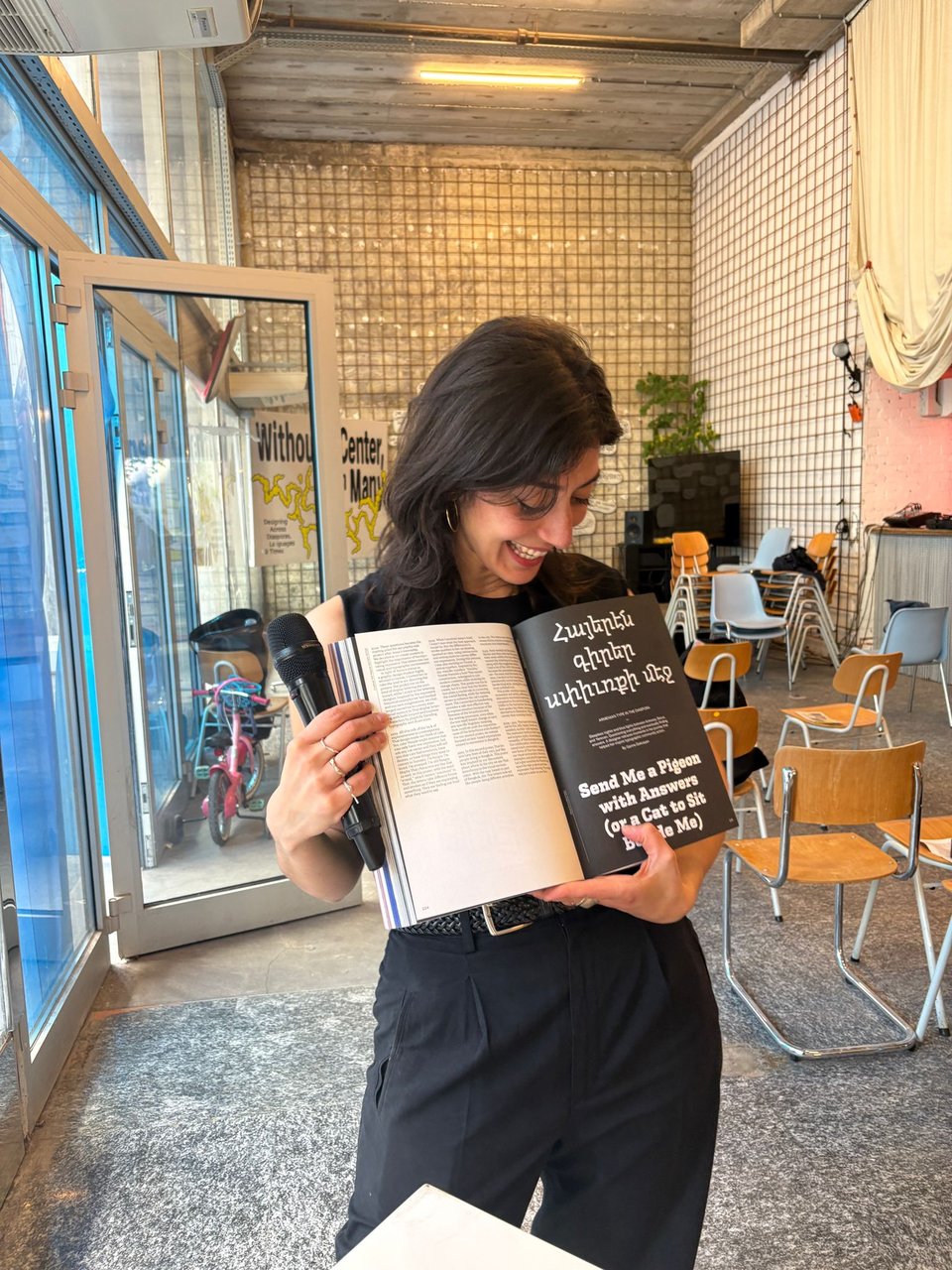 a person smiles and holds a book opened to a spread in her hands