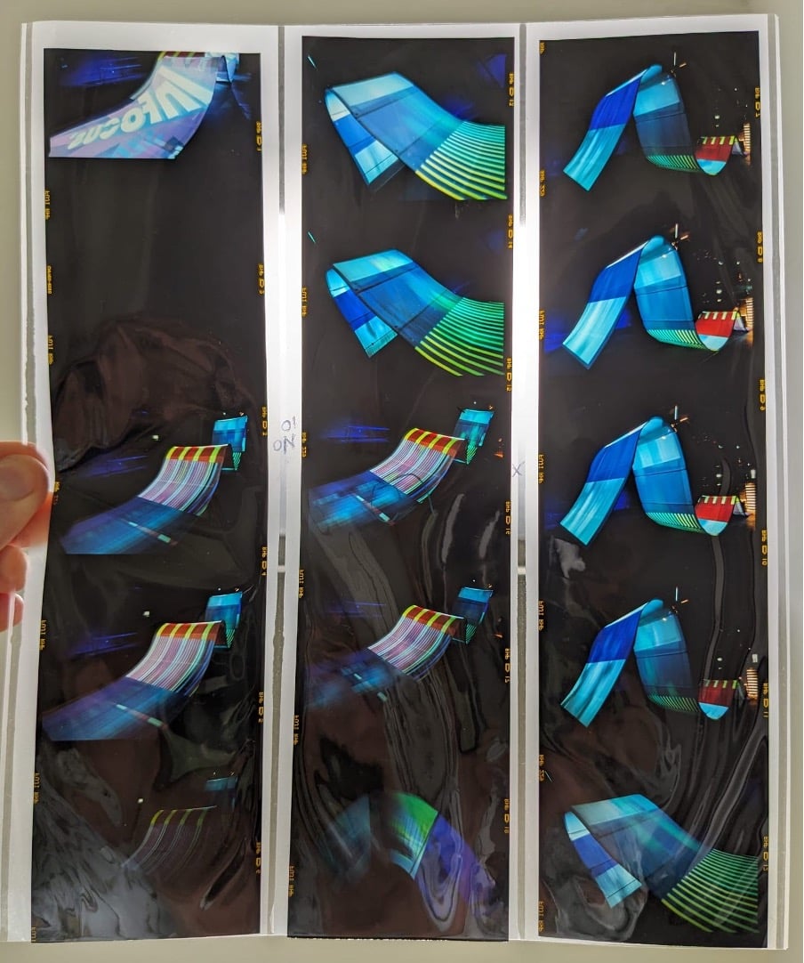 A sheet of colour transparencies with multiple images of a colourful wave sculpture