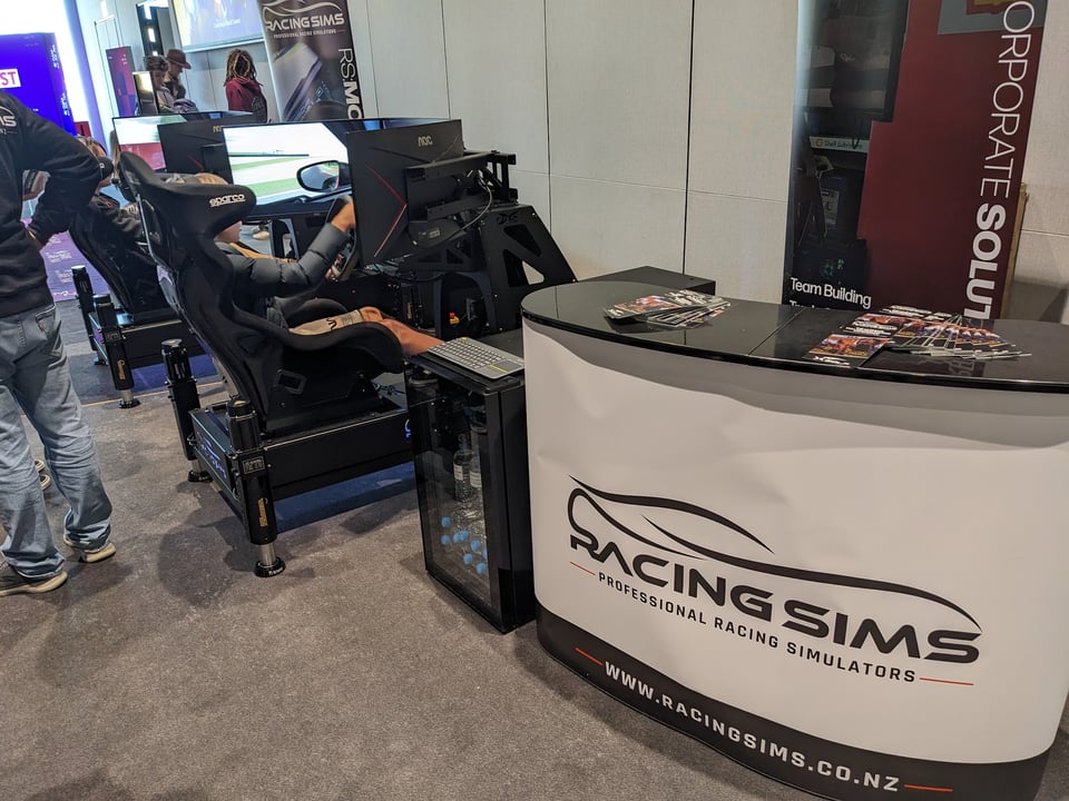 Racing sims setup at Armageddon including two motion rigs and signage