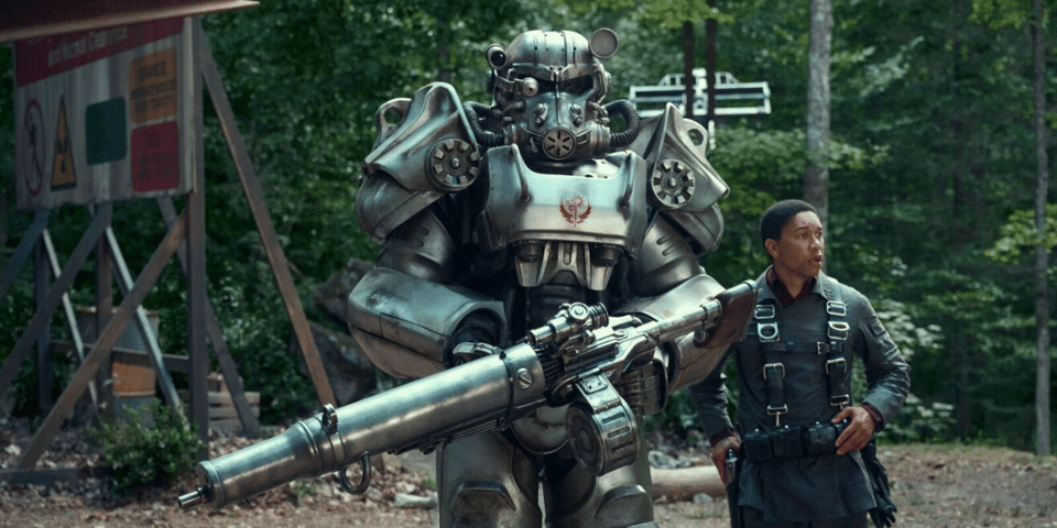 A steel knight holds a big gun next to his squire.