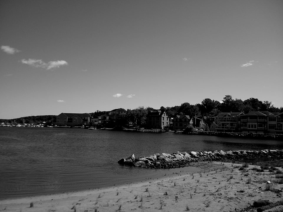 a black and white photo of a small coastal town called mahone bay