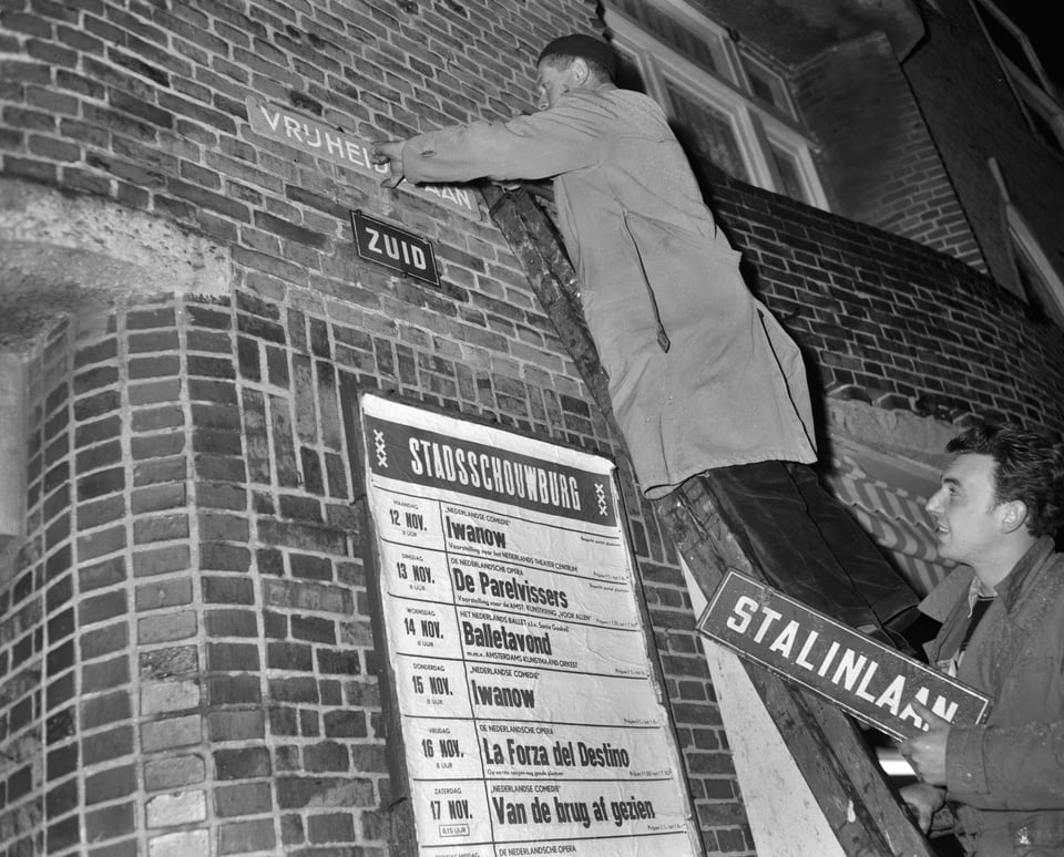 workers swap a road sign reading "Stalinlaan" for one reading "Vrijheidslaan"