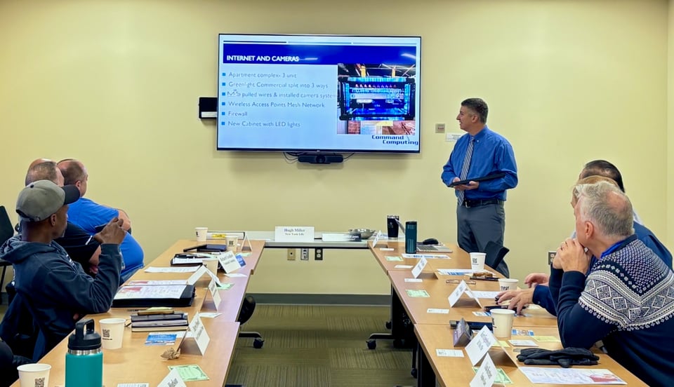 Rich talks about his services to NRG members seated and viewing his presentation slide.