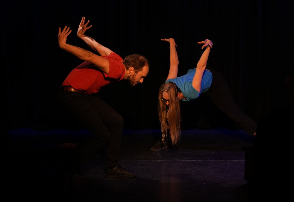 Two people on a stage in weird positions