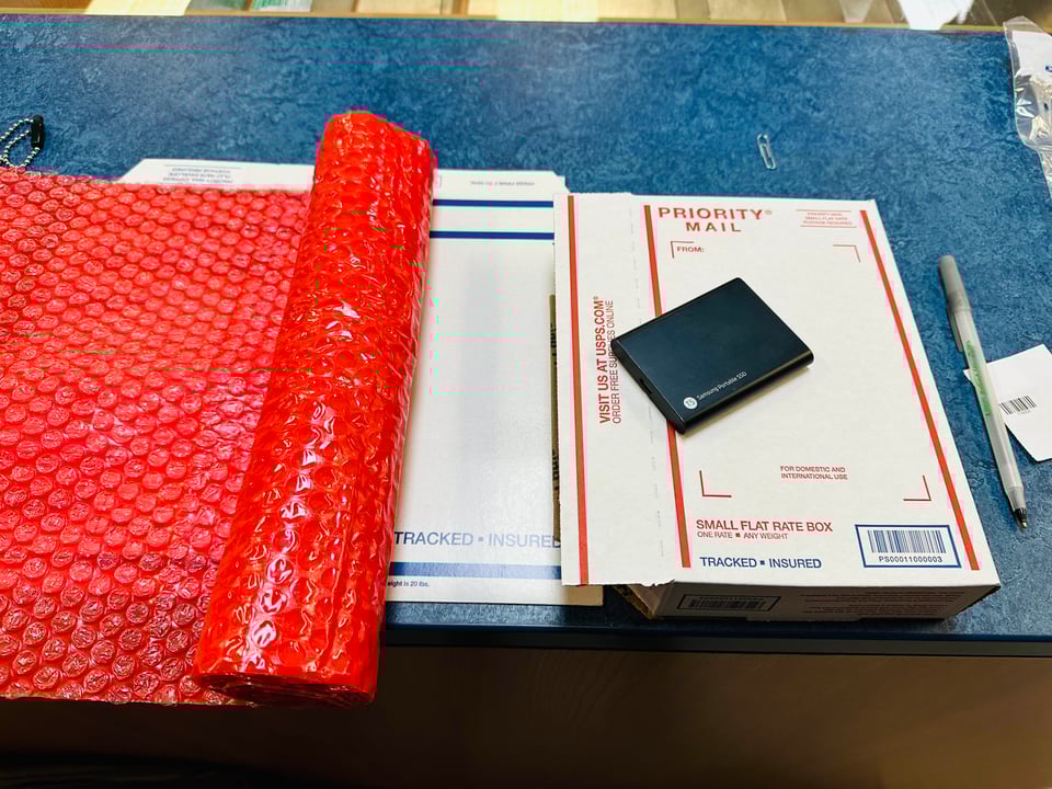 An SSD with the book in the post office atop shipping materials