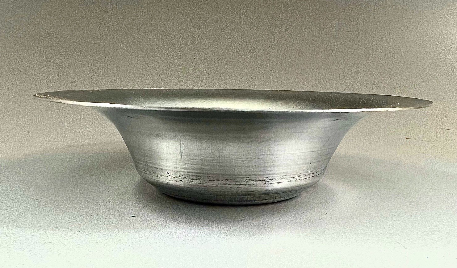 side view of the aluminum bowl with a wide top that tapers down to a narrower bottom