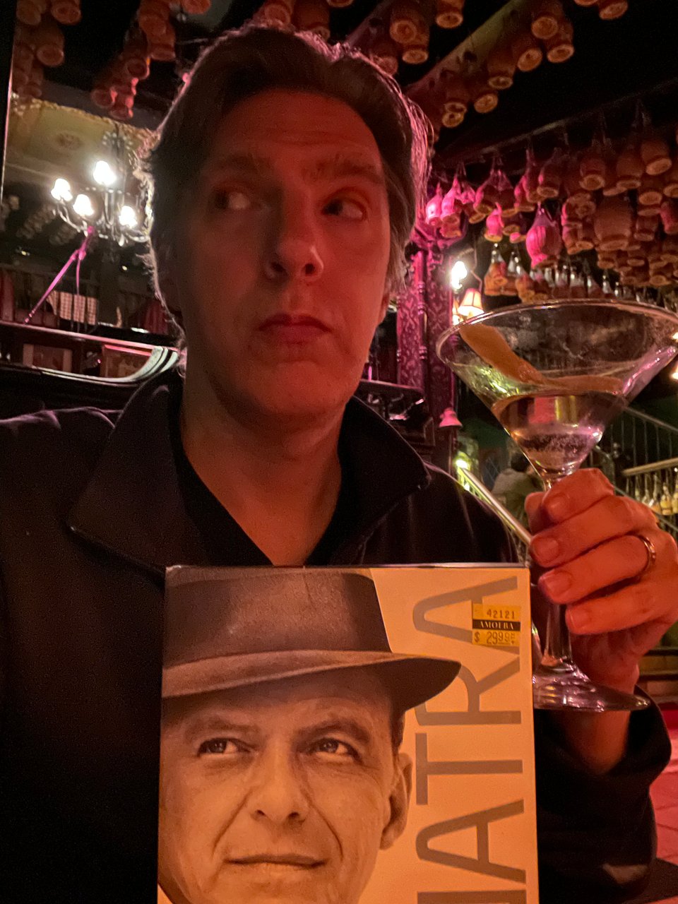 A picture of a man with a martini and a Sinatra DVD collection in an Italian restaurant