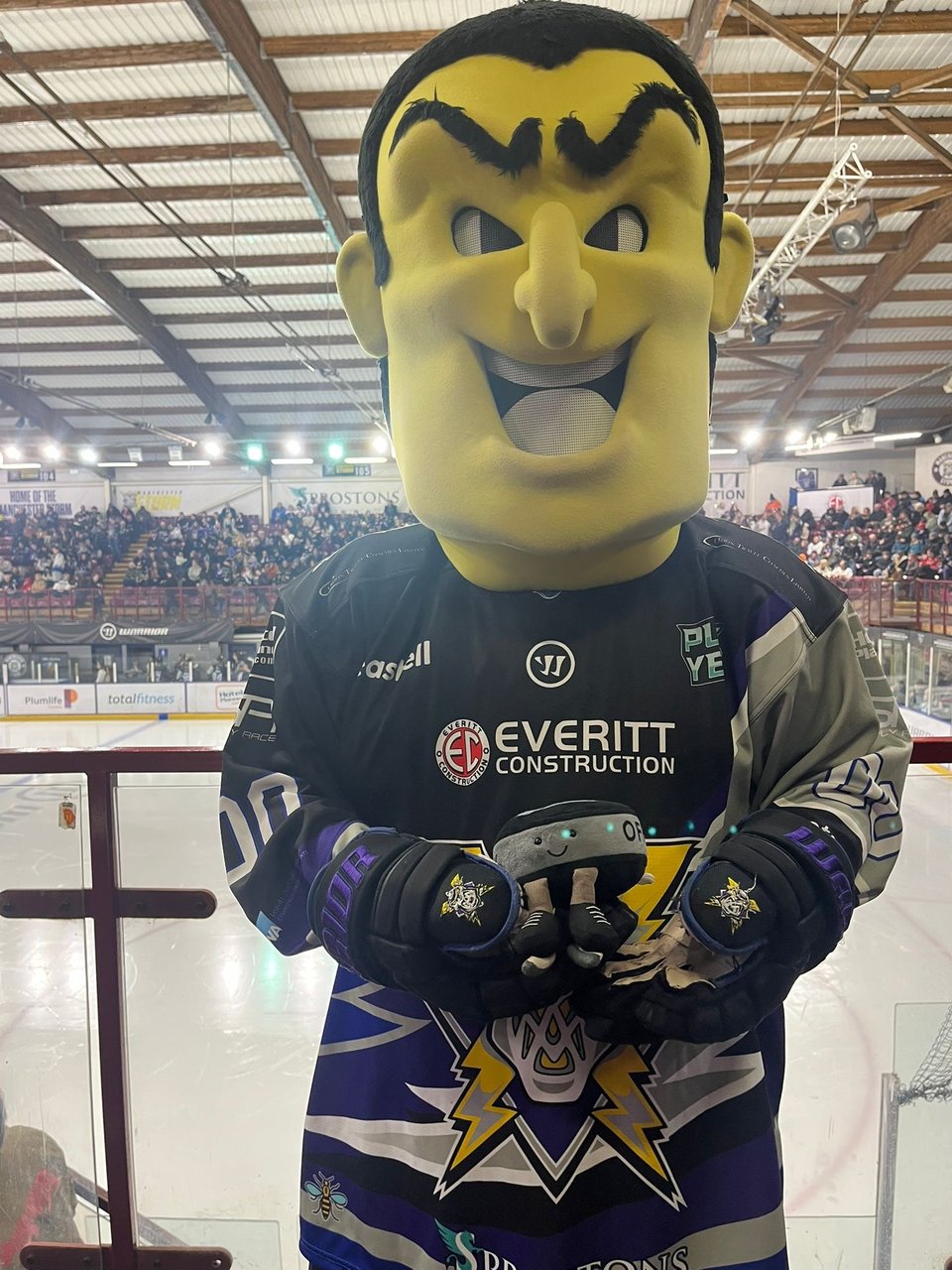 A man wearing a purple Manchester Storm top and a giant yellow foam head.
