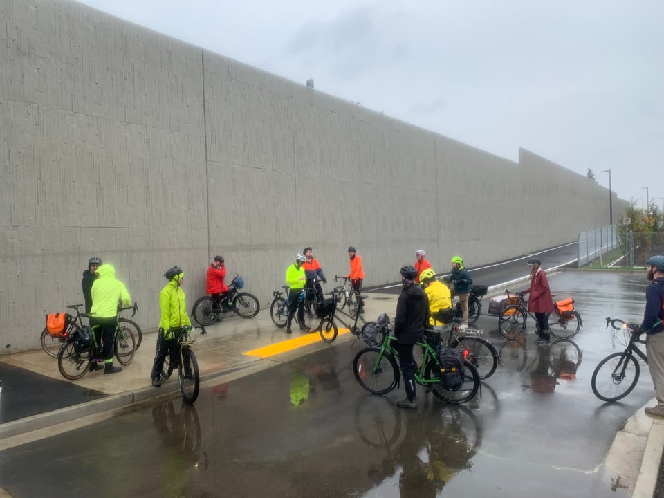 Tour attendees with bikes look at a point of interest near Interstate 5 in Shoreline.