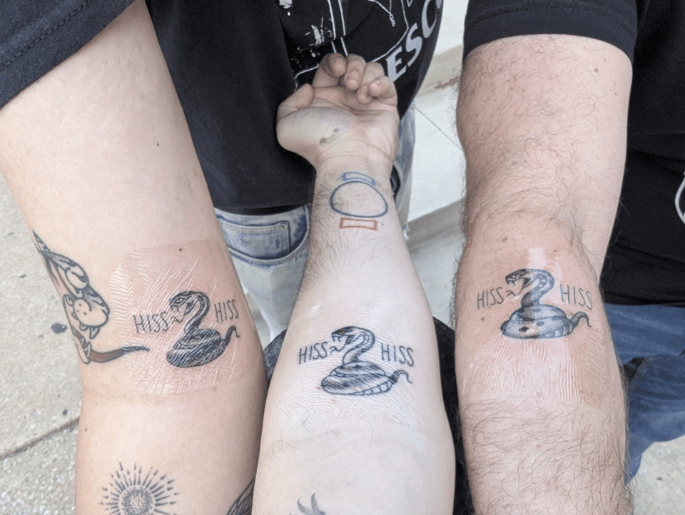 A set of three matching snake tattoos with the words HISS HISS.