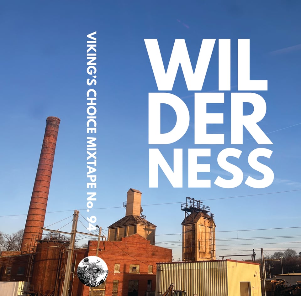 Cassette j-card layout with mixtape title: WILDERNESS. Photo features railway buildings and telephone wires.