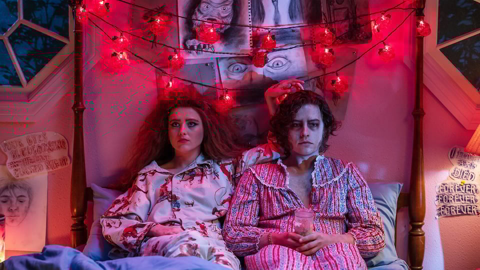 A frame from Lisa Frankenstein with Lisa and The Creature in bed.