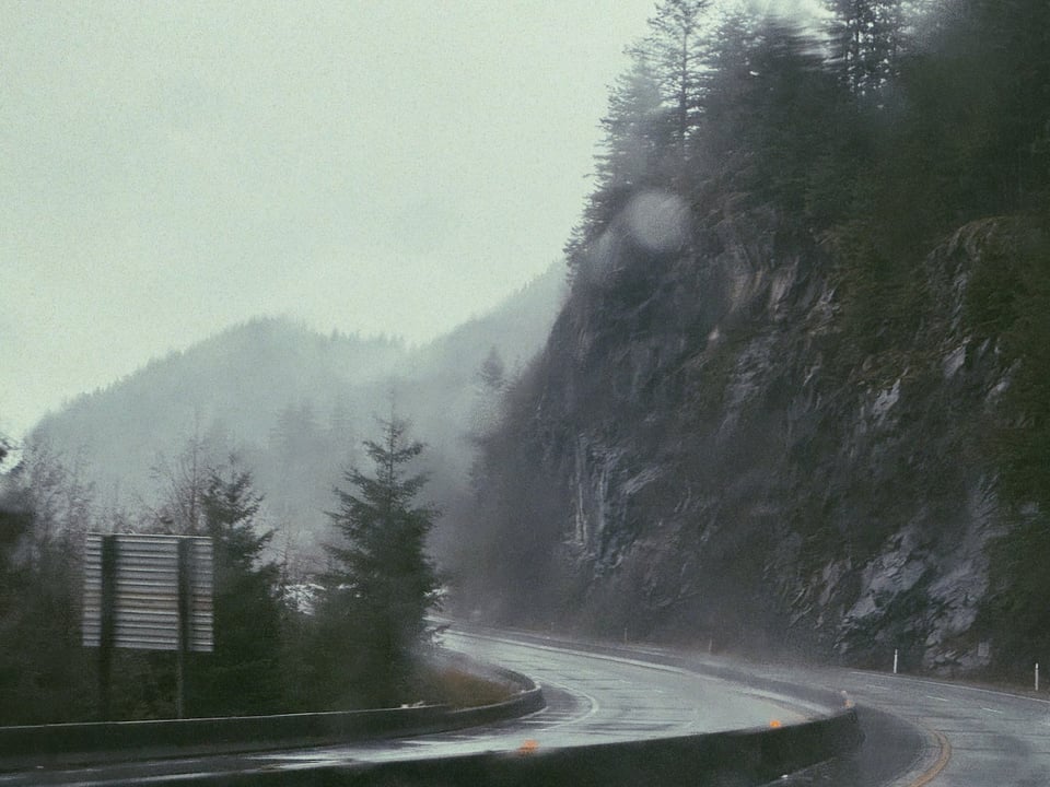 a very rainy and windy road through the mountains