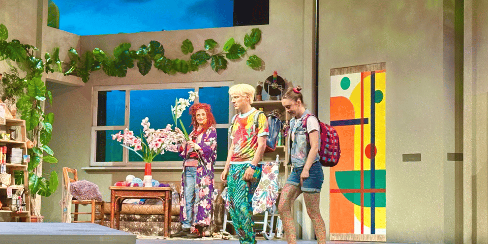 Three highly-colourful people in a highly-colourful room.