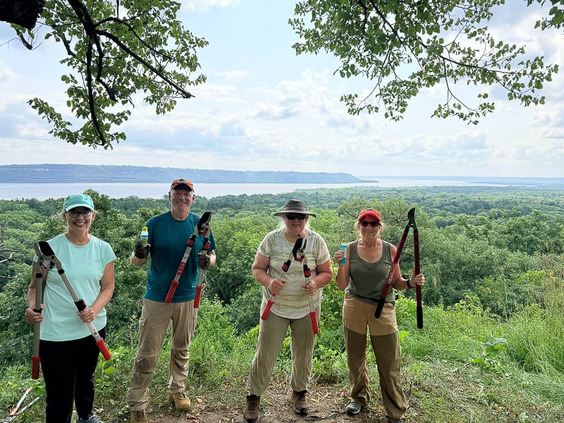 On July 21, a few Frontenac State Park Association volunteers gathered at Eagle Point to get rid of some pesky buckthorn that was significantly impeding the view there. Never have you seen such vigorous chopping and clipping! From left: Tracie Henkel, Brian Henkel, Ethel Zimmerman and Barb Partington. / Photo taken by a friendly hiker using one of their cell phones