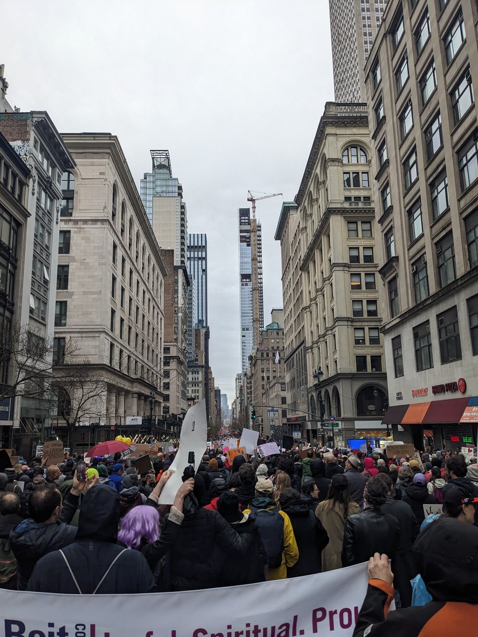 A crowd of people marching down Fifth Avenue at the Hands Off! rally.