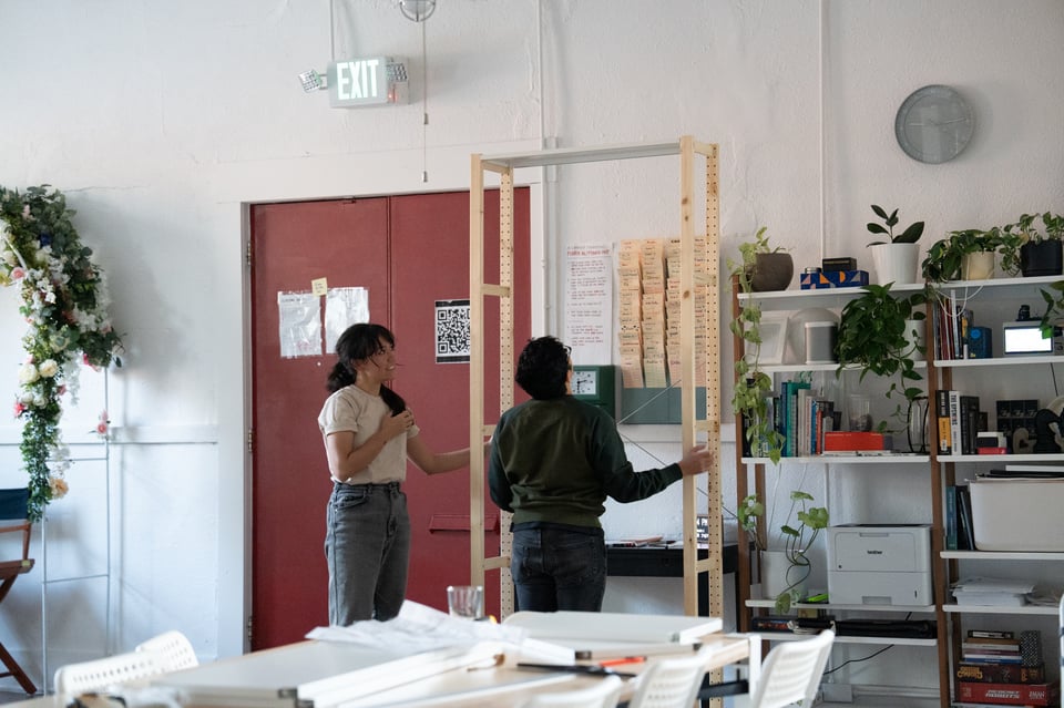 Livvy and Norton evaluating a bookcase.