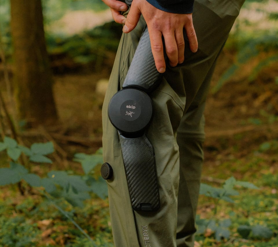 A person wearing a robotic-assisted knee brace in the woods.