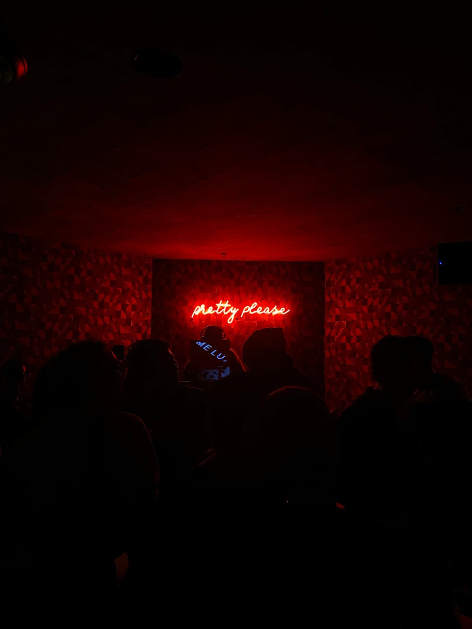 people in a dark room with a neon sign