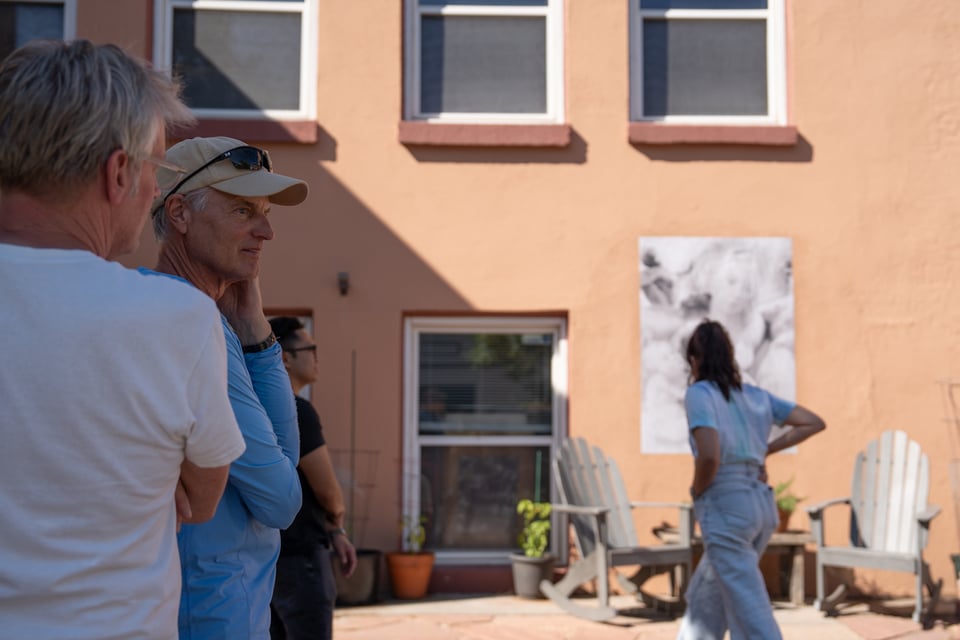 A group of people standing around some outdoor art.