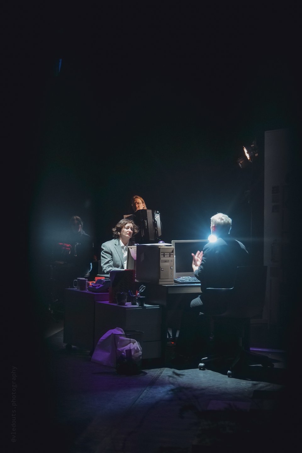 two actresses at a desk on a stage