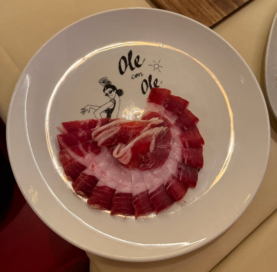 Spanish jamon fanned out as the "skirt" of illustration of Flamenco dancer on a plate at Txula Steak in New York City.