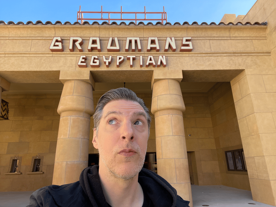 A picture of a man staring up and to the right with Grauman's Egyptian Theater behind him