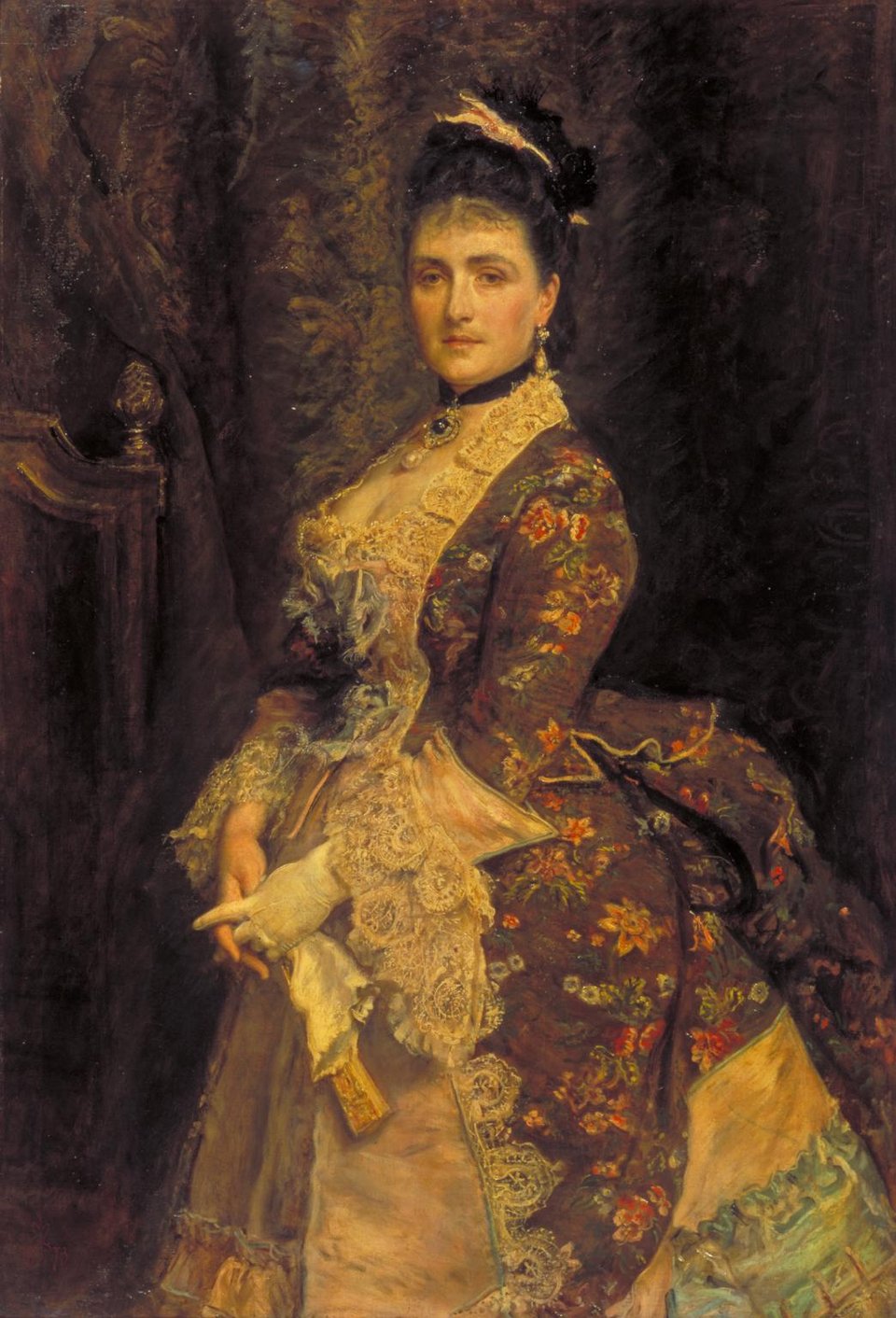 A portrait of a woman with dark hair wearing a floral gown over a white skirt.