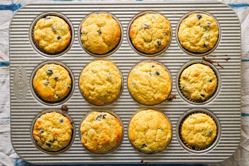 A muffin tin filled with twelve blueberry muffins