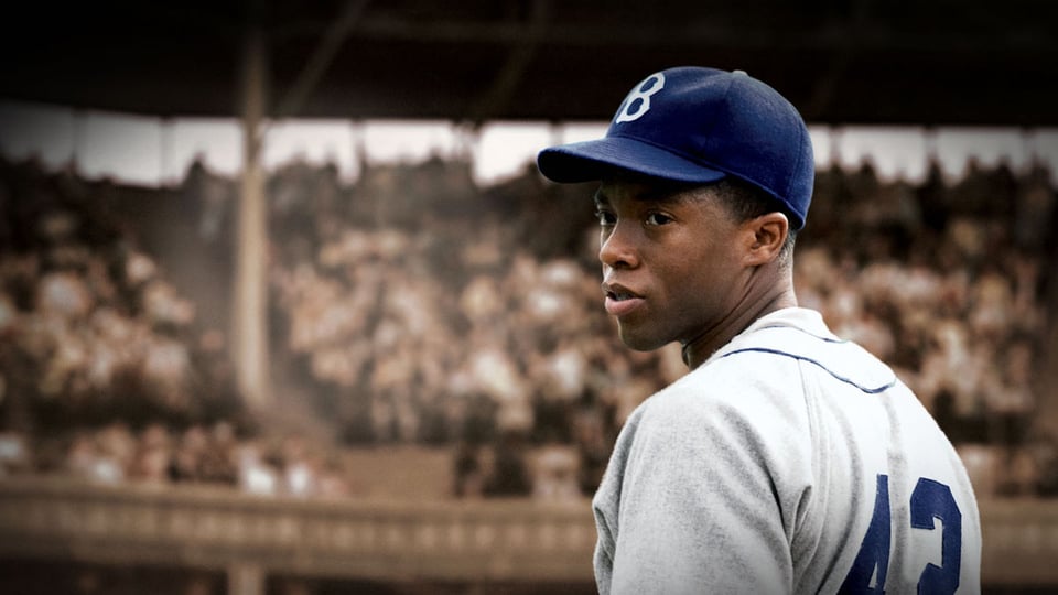 An image from 42, Jackie Robinson looks behind his shoulder.