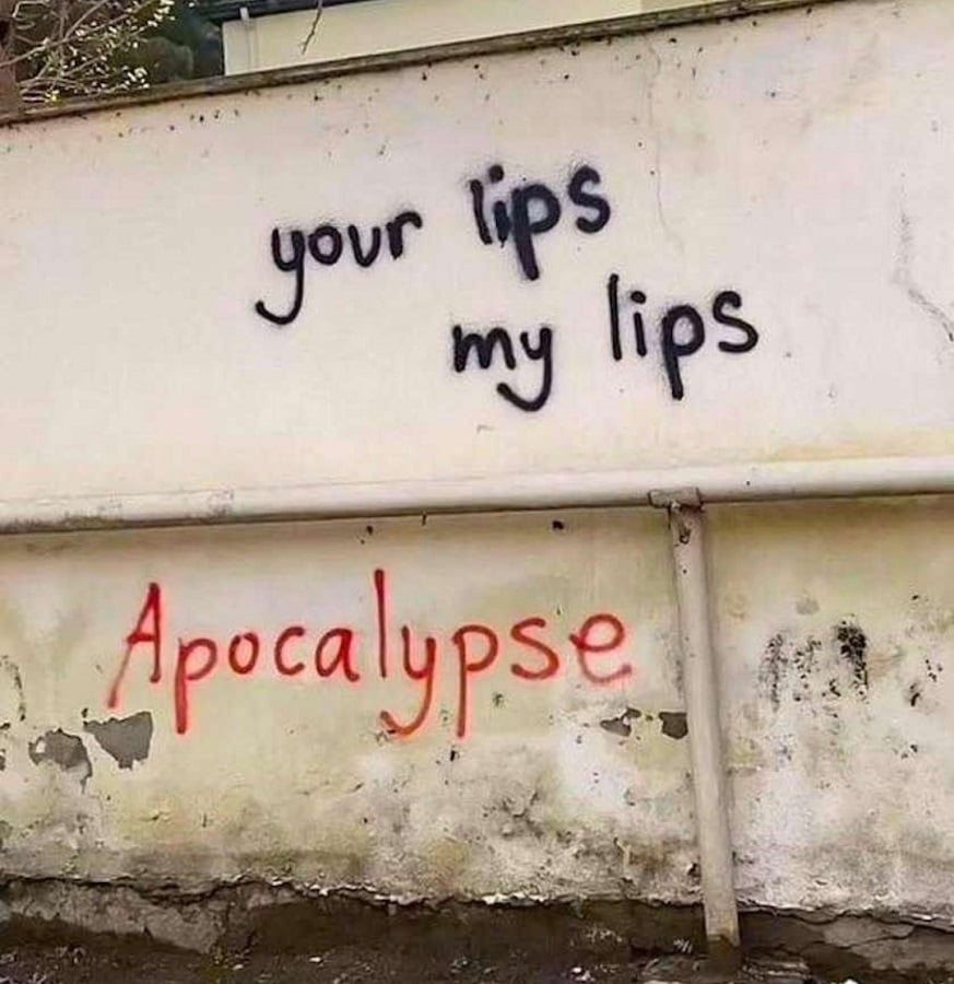 Photo of some graffiti sprayed onto a wall. Black text reads: your lips my lips. Below someone has added red text that reads: Apocalypse.