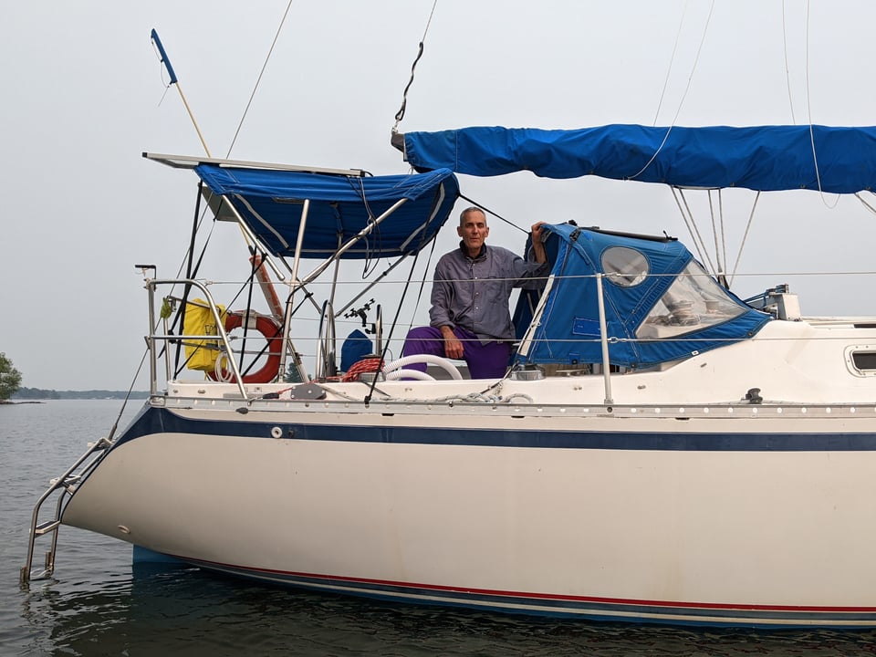 Andy standing in the cockpit of Heartbeat at anchor.