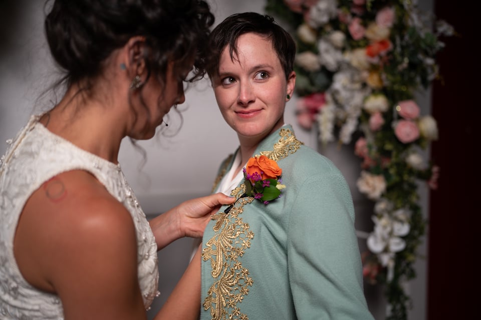 Allyson affixing a boutonniere on Madison’s coat.