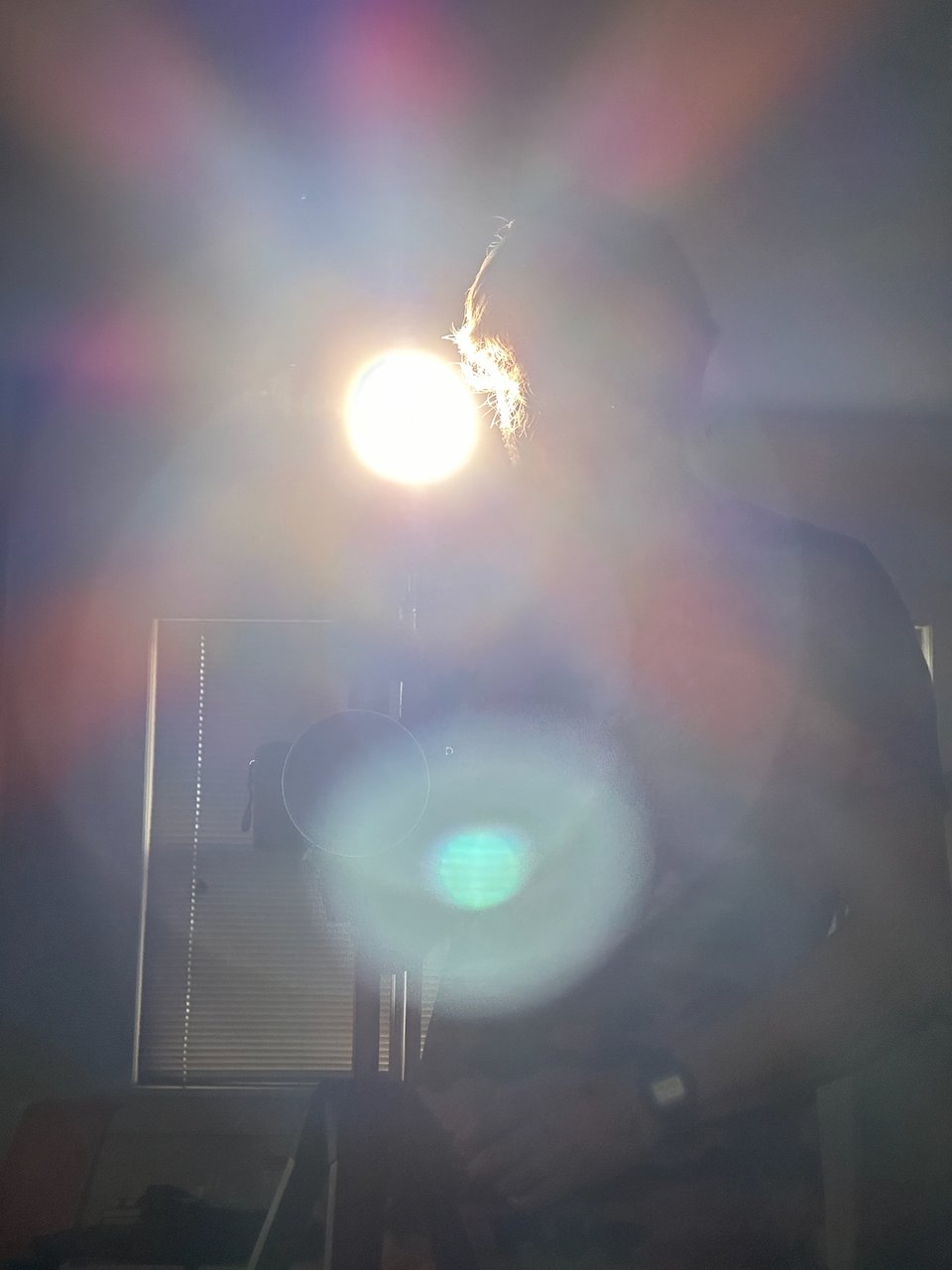 A washed out photo of Drew looking at a camera.