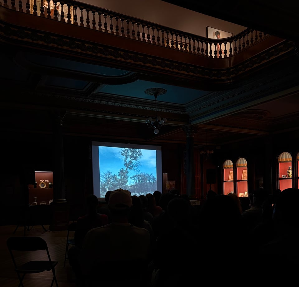 A projector screen with Oak trees projected onto it in the ballroom at the Crocker Art Museum