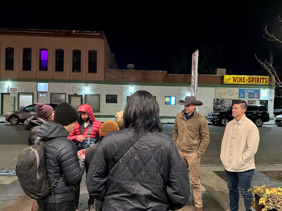 A group of people standing around outside.