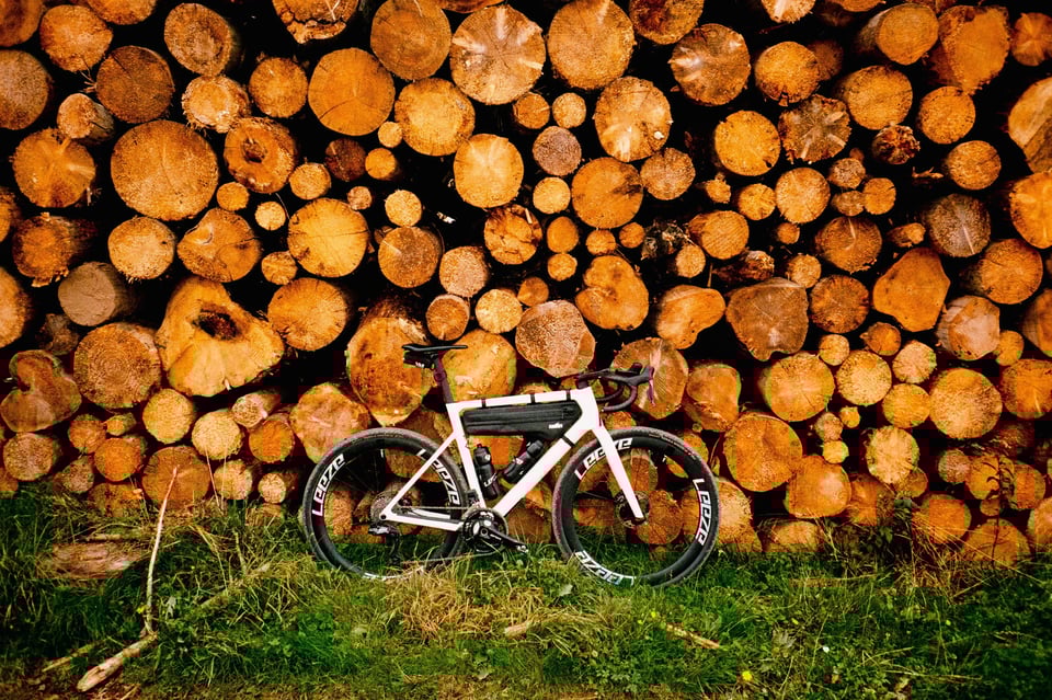 A bike in front of a pile of wood