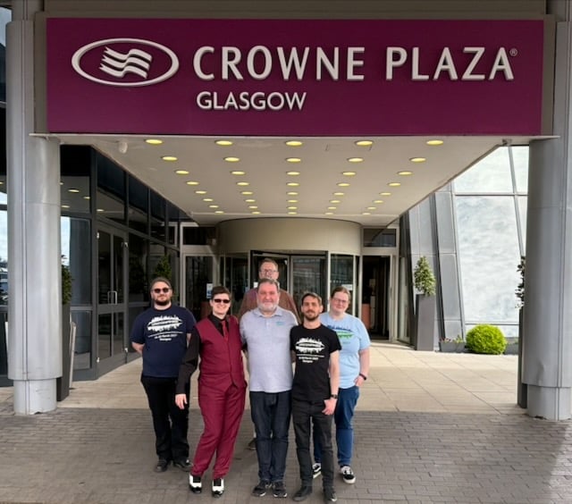 A group of people standing in front of the Crowne Plaza entrance