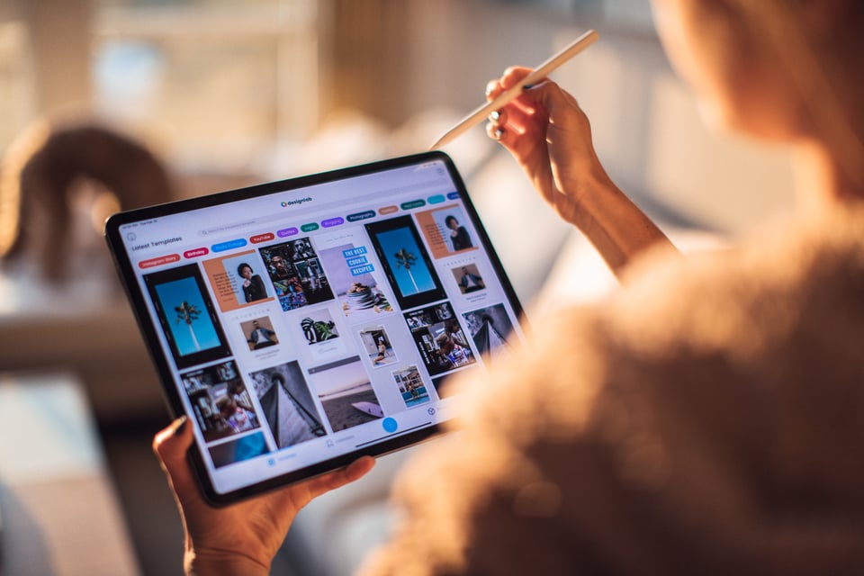 Image of a person looking at a tablet in their hands.