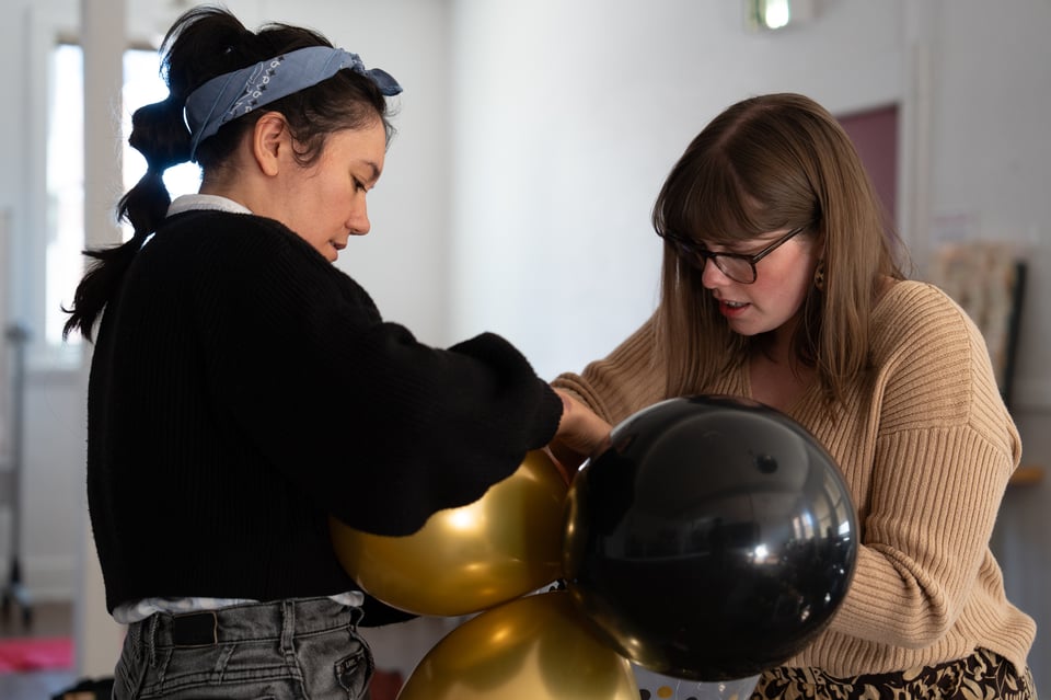 Livvy and Lizzie tying balloons together.