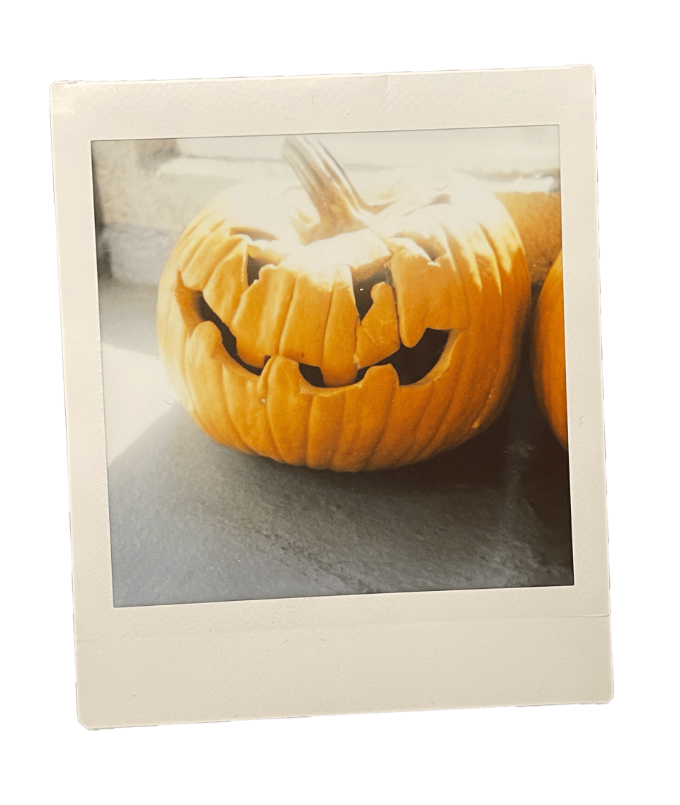 A polaroid photo of a rotting pumpkin that is halfway collapsed in on itself