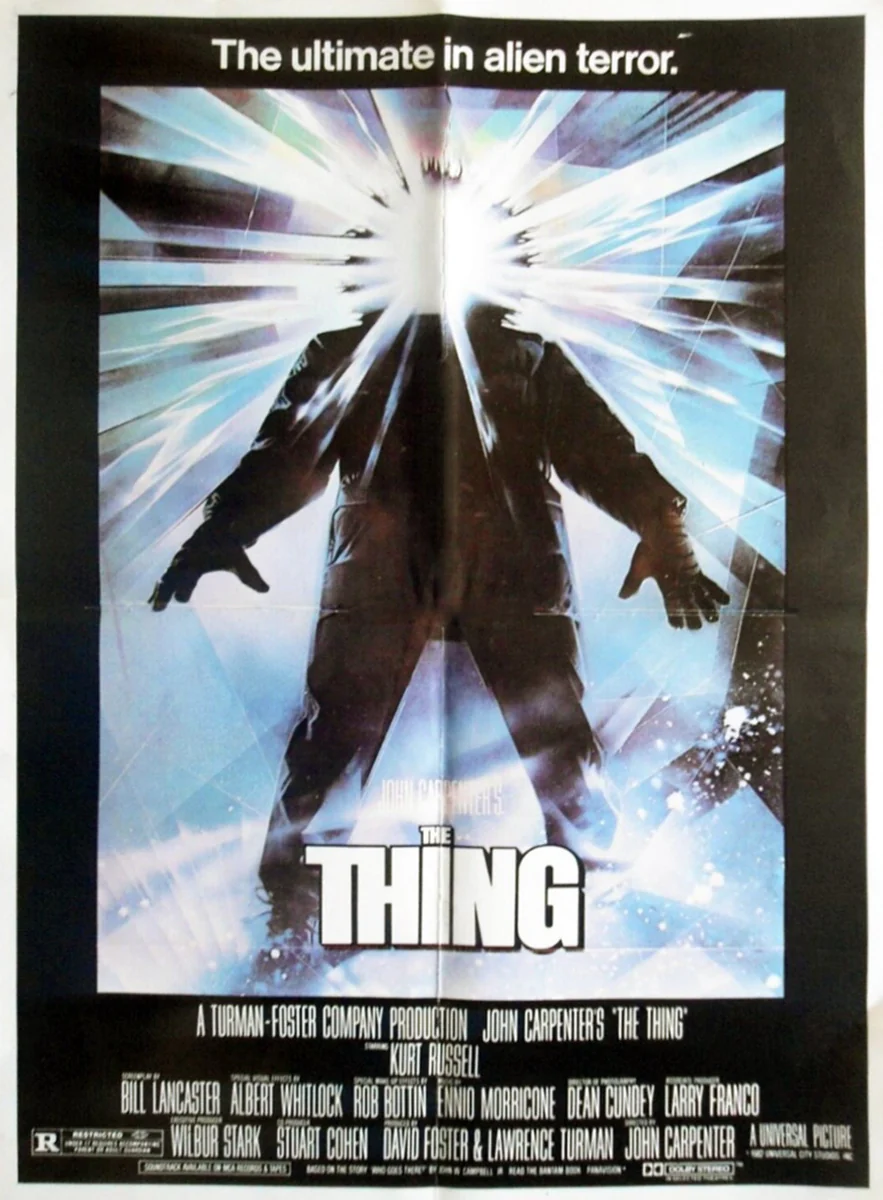 The iconic poster John Carpenter's movie version of "The Thing". It shows a humanoid figure with an explosion of white rays radiating from, and obscuring, its head. At the top of the poster is the tagline "the ultimate in alien terror". At the bottom is the title "The Thing". Then below that are the movie credits.
