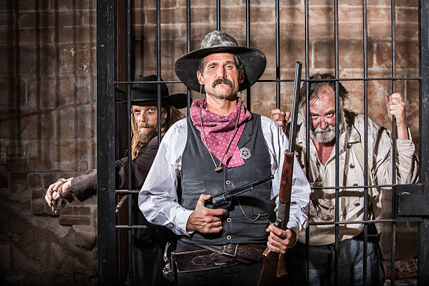sheriff stands in front of two captured no gooders