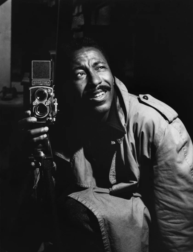A photo of the photographer Gordon Parks holding his Rolleiflex medium-format film camera.