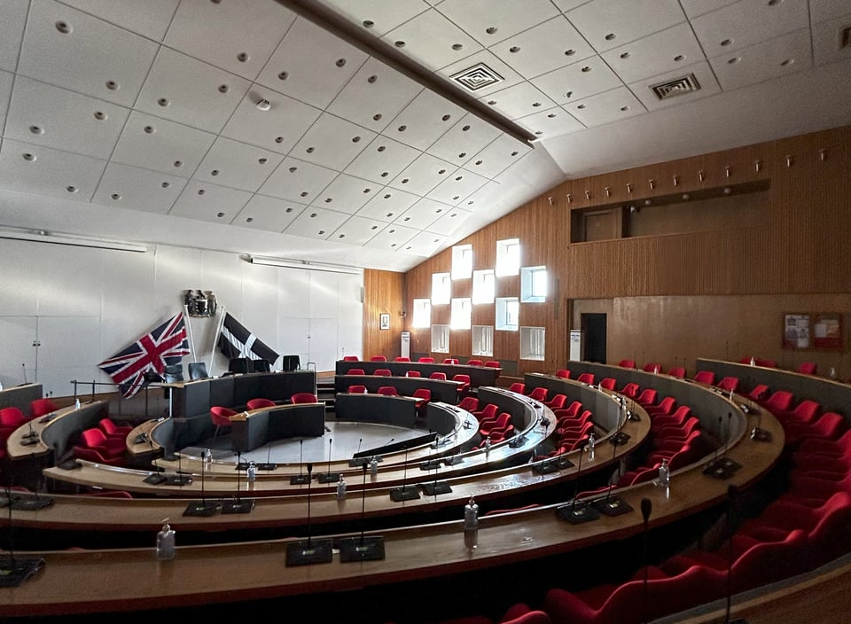 The wooden ampitheatre of the council chamber. The southern interal wall matches he original drawing, with a checkerboard of windows set into wooden panelling.