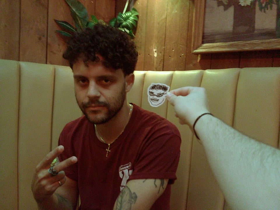 me throwing up a peace sign next to a sticker of my own face.