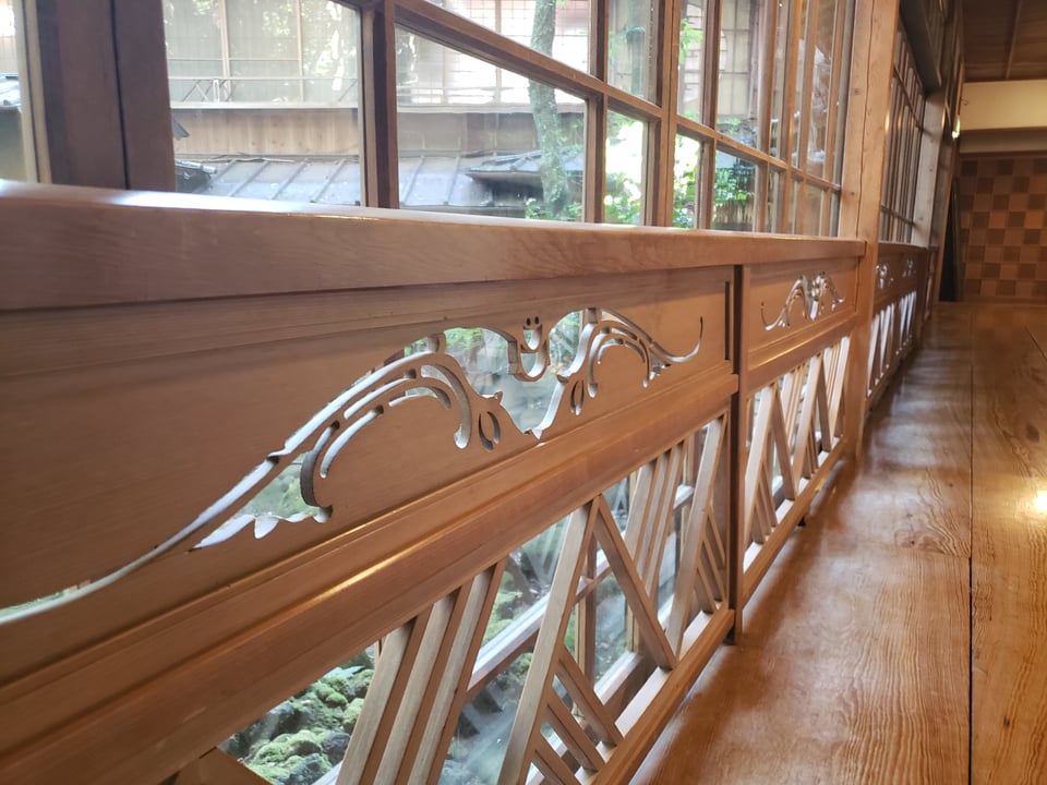 A close-up of the bat guardian carved into a railing.